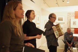 Zwei Frauen singen und werden von einem Mann am Akkordeon begleitet. Im Hintergrund ein &auml;lterer Zuschauer. 