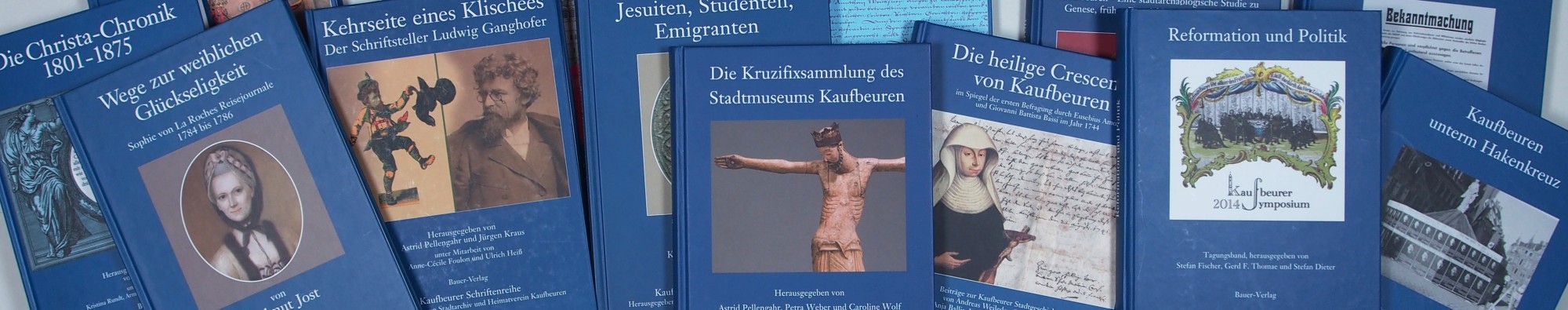 Kaufbeurer Schriftenreihe: mehrere dunkelblaue B&uuml;cher liegen sich teilweise &uuml;berschneidend nebeneinander