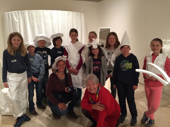 10 Sch&uuml;ler:innen und eine Lehrerin mit Frau Petri, teilweise verkleidet mit Papieraccessoires (H&uuml;ten, Hosen, Kleid,...)