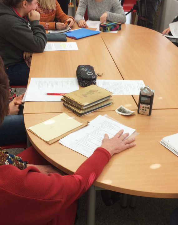 drei Sch&uuml;lerinnen sprechen miteinander an einem Tisch