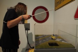 Ein Besucher lenkt in einer Vitrine mit einer "Angel" eine Stra&szlig;enwalze &uuml;ber ein Stra&szlig;enmodell