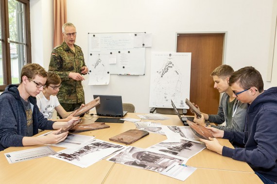 vier Sch&uuml;ler mit Herrn Tietje bei der Recherchearbeit am Schreibtisch