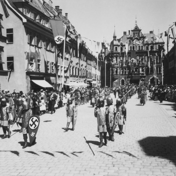 Foto des T&auml;nzelfestumzuges in der Kaiser-Max-Stra&szlig;e mit Rathaus 1937
