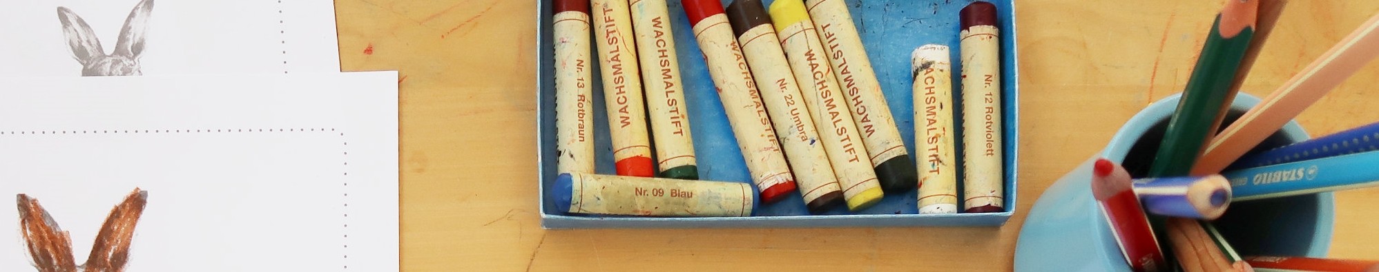 Tisch mit Malvorlagen, Wachsmalstiften und Buntstifte