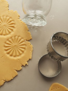 Ausstecher neben dem ausgerollten Keksteig, mit dem Glasr&uuml;cken wurden zwei Muster in den Teig gepresst. 