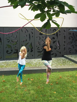 Ein M&auml;dchen und eine Frau im Museumshof machen die Yoga-Figur "Der Adler"