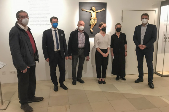 sechs Personen stehend vor dem Christk&ouml;nig in der Dauerausstellung, alle mit FFP2-Maske