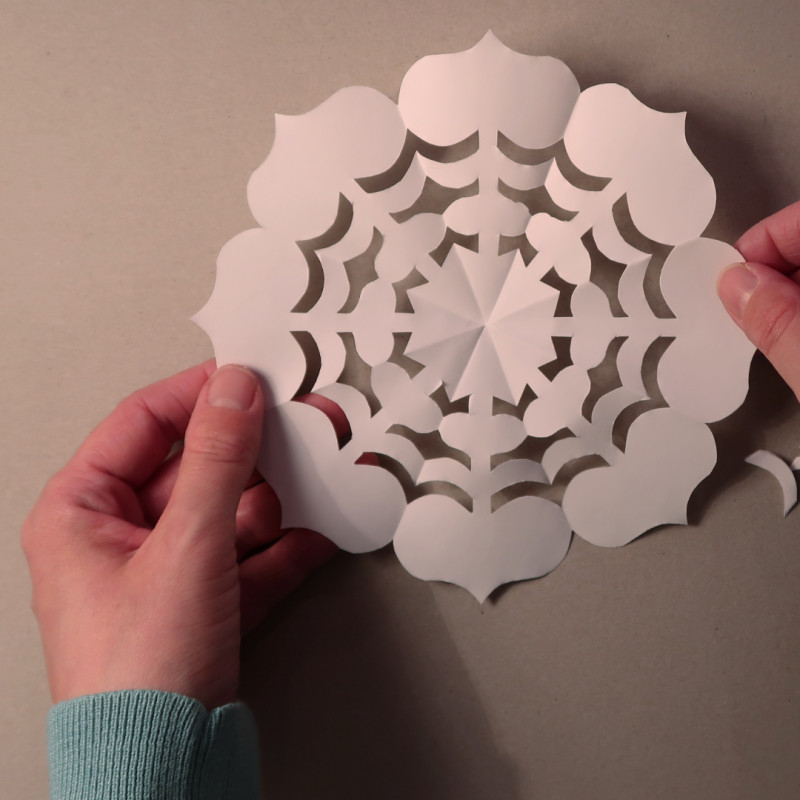 Zwei H&auml;nde halten einen Scherenschnitt mit Herzchen