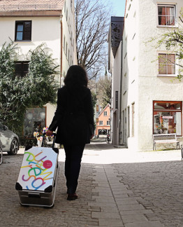 Eine Frau zieht den neuen Museumskoffer im Kaiserg&auml;&szlig;chen Richtung Stadtmuseum