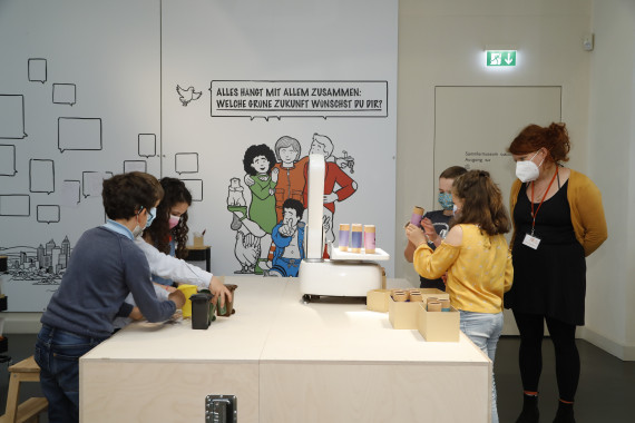 links hantieren Kinder mit Minim&uuml;lltonnen, rechts sind Kinder und eine Frau an einer CO2-Waageauf 